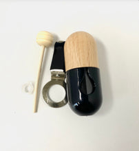 Load image into Gallery viewer, Close-up of a wooden-topped car vent diffuser with black glass bottle and metal clip for easy attachment.