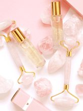 Load image into Gallery viewer, Rose quartz roller with beauty accessories and pink stones, luxury skincare and self-care routine.