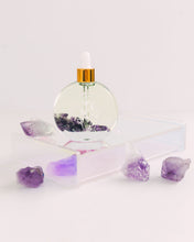Load image into Gallery viewer, Bopo Women Halo Hair Drops bottle on a soft lilac surface with gold accents and natural crystals beside it.