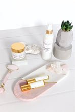 Load image into Gallery viewer, Rose quartz facial roller displayed beside face serum and greenery, elegant skincare and wellness set.