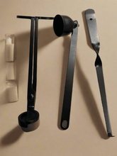 Load image into Gallery viewer, Black candle care kit tools including wick trimmer, snuffer, and dipper laid flat beside candles.
