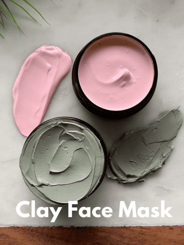 Clay face mask jars with pink and green clays on wooden board, hydrating and detoxifying skincare treatment.