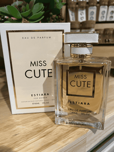 Miss Cute Eau de Parfum 90ml by Estiara, clear glass bottle with white and gold accents, displayed with matching packaging.