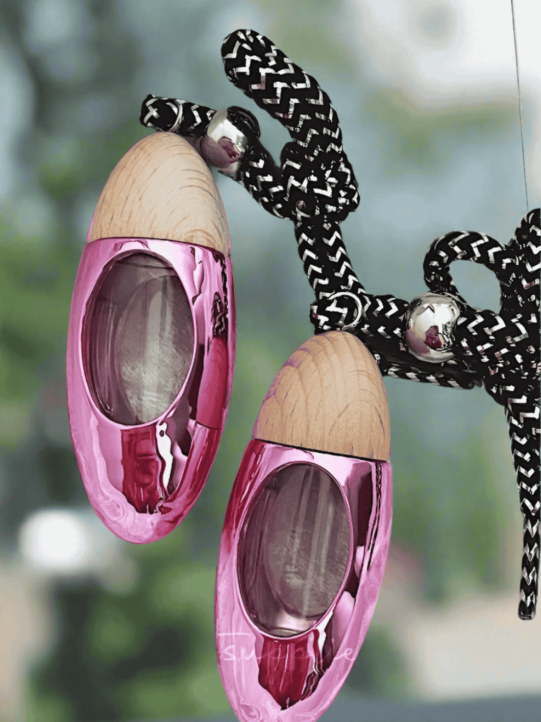Pink bullet car diffuser with wood top hanging by cord, releasing fragrance for cars and small spaces.