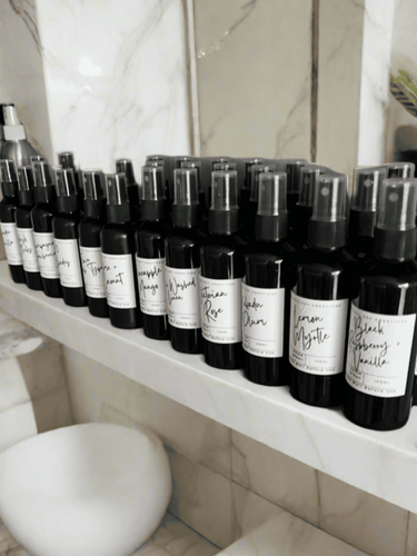 Row of 100ml room spray bottles displayed on shelf, natural home fragrance and deodorizer for fresh, clean scent.