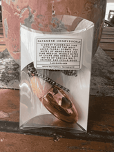 Load image into Gallery viewer, Rose gold bullet car diffuser with wooden cap shown in retail packaging by Natural Soy Creations.
