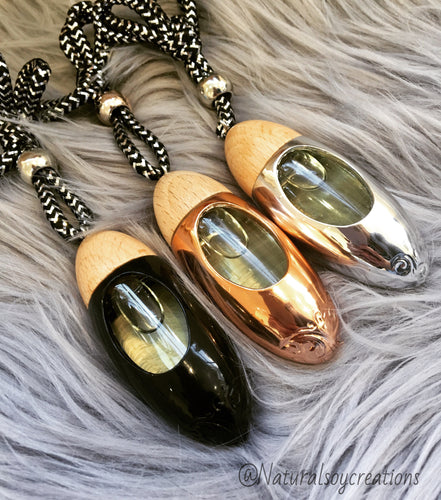 Set of three rose gold bullet car diffusers with wood tops and hanging cords, displayed together.