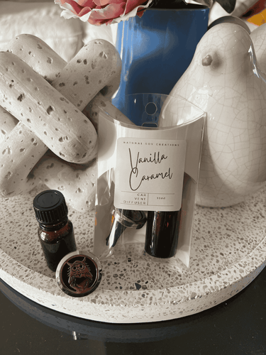 Natural Soy Creations round clip car vent diffuser set with fragrance oil and packaging displayed on a tray.