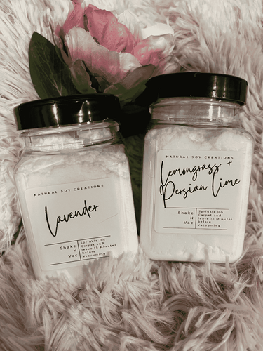 Two jars of Shake ‘N’ Vac natural carpet deodorizer on soft fabric, eco-friendly powder with essential oils for freshness.