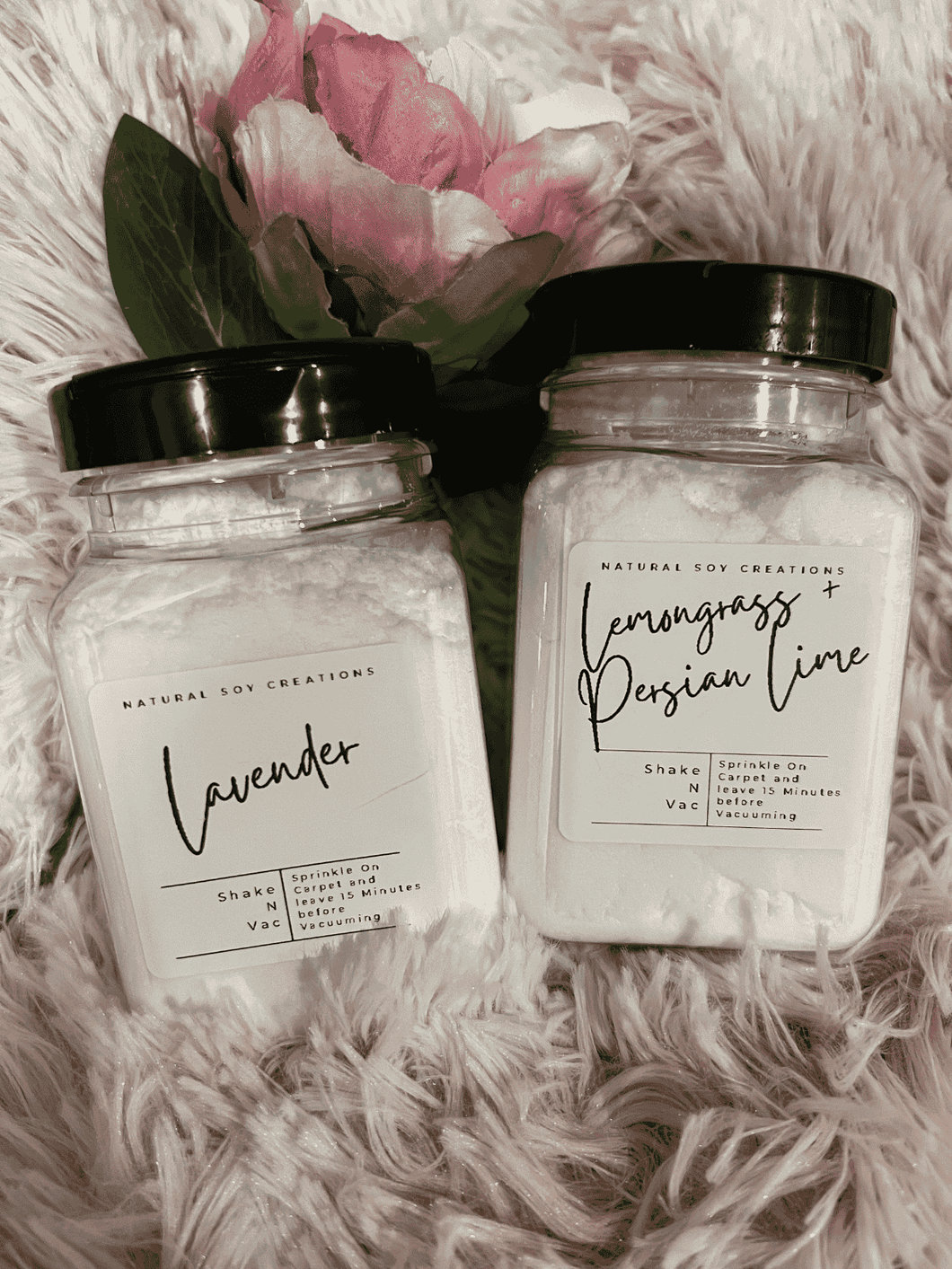 Two jars of Shake ‘N’ Vac natural carpet deodorizer on soft fabric, eco-friendly powder with essential oils for freshness.