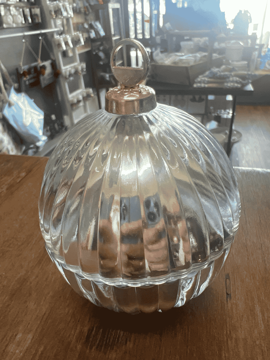 Elegant silver mini bauble candle with ribbed glass design and gold lid, displayed on a wooden surface.