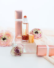 Load image into Gallery viewer, Ember crystal-infused perfume oil by Bopo Women displayed with flowers, elegant aromatherapy roller for self-care and balance.
