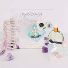Load image into Gallery viewer, Flat lay of Bopo Women Halo Hair Drops Gift Set with lilac acetate comb, nourishing hair oil, and crystals on a soft background.
