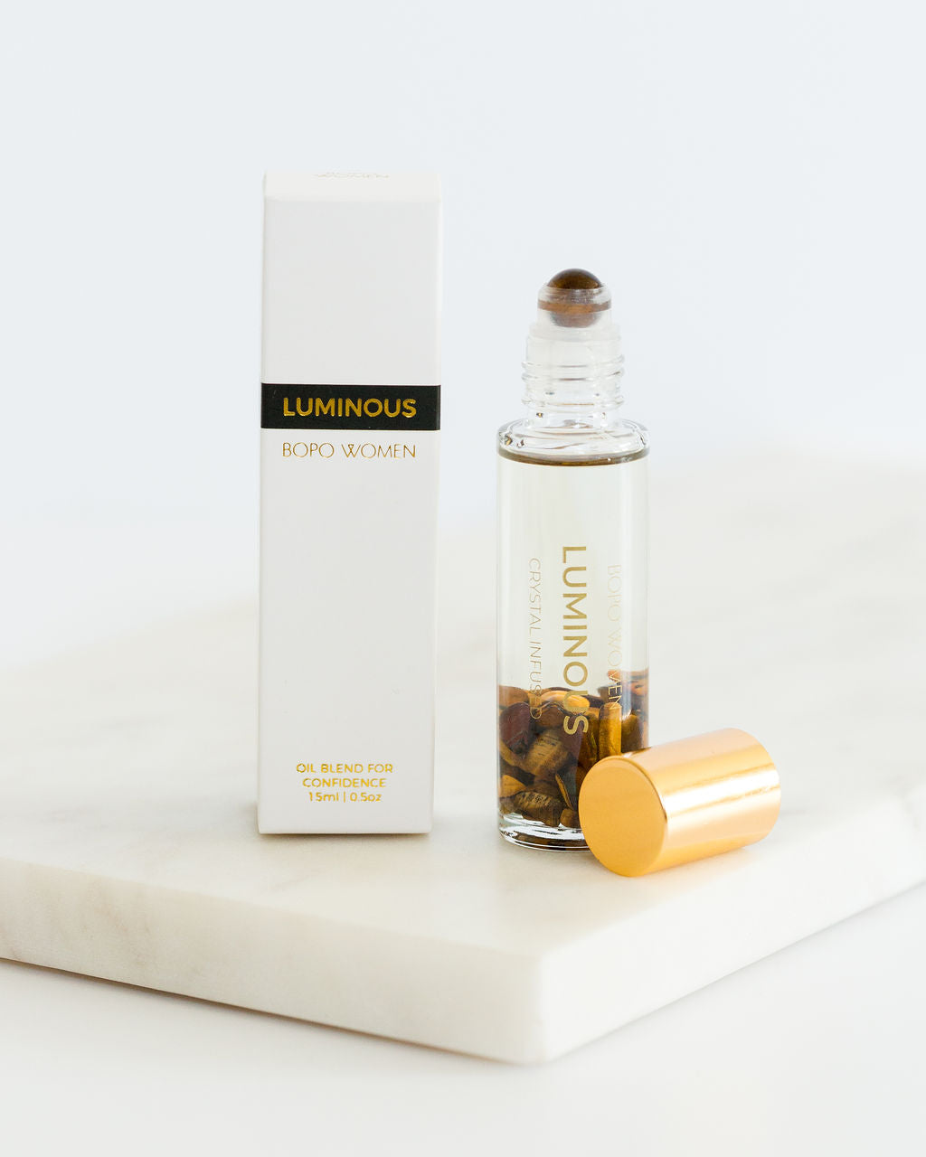 Luminous crystal perfume roller by Bopo Women with box and gold lid, infused with Tiger’s Eye for confidence and inner strength.